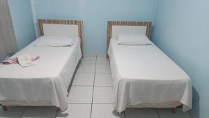 Dos camas una al lado de la otra en una habitación. en Hotel BR, en Videira