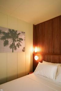 Un dormitorio con una cama blanca y una lámpara. en Lewis house sweet, en San Juan