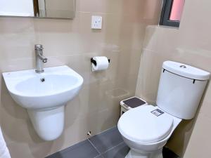 Un baño con un inodoro blanco y un lavabo. en Serene Heights Hotel, en Maiyegun