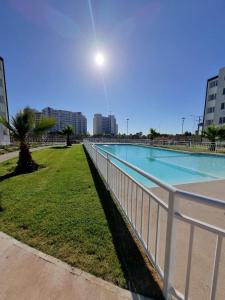 ein weißer Zaun neben einem Pool in der Unterkunft Departamento a pasos del Faro playa la Serena in La Serena