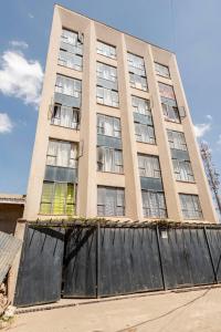 ein hohes Gebäude mit einem Zaun davor in der Unterkunft adtek homes Room KIBALI in Nairobi + 26 Fotos