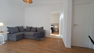 a living room with a gray couch and a hallway at Antica Dimora Petito Luxury Suites in Matera