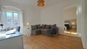 a living room with a gray couch and a bedroom at Antica Dimora Petito Luxury Suites in Matera