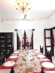a dining room with a long table with a chandelier at Chan Maison @ Lakshmi Gardens in Puducherry