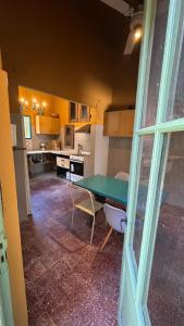 a kitchen with a green table in a room at A la Gurda Hostel - Barrio Sur in San Miguel de Tucumán