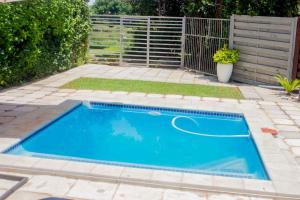 a swimming pool in a garden with a fence at Serenity in Hartbeespoort