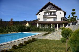 普雷代亚尔Infinity Villa的一栋房子前面有游泳池