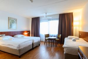 De Rijper Eilanden في دي رايب: غرفة فندق بها سريران وطاولة