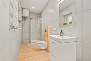 een witte badkamer met een toilet en een wastafel bij Central Platinum Apartments 5 in Rybnik