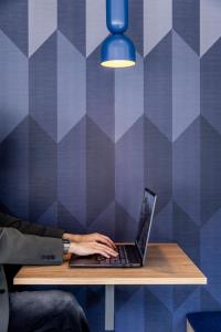 a person typing on a laptop computer on a table at Holiday Inn Express Porto - Boavista by IHG in Porto +97 photos