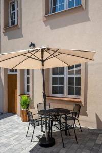 een tafel en stoelen onder een parasol op een terras bij Central Platinum Apartments 5 in Rybnik