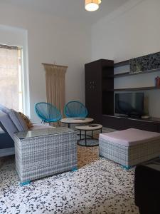 a living room with couches and chairs and a tv at Villetta Angela in Torre San Giovanni Ugento