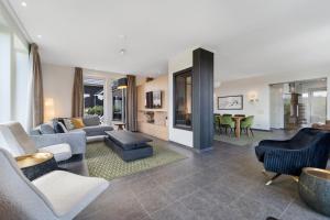 un soggiorno con un divano, sedie e un tavolo di Wijndomein Joris a Slenaken