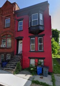 a red house with a staircase in front of it at 2 floor townhouse w patio & yard, luxury amenities in Albany