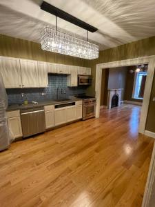 a large kitchen with wooden floors and a chandelier at 2 floor townhouse w patio & yard, luxury amenities in Albany
