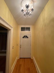 a hallway with a white door and a chandelier at 2 floor townhouse w patio & yard, luxury amenities in Albany