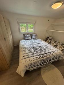 una cama grande en una habitación con ventana en Chalet de pêche Le Caribou, en Rozay-en-Brie