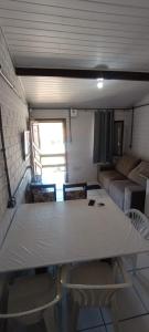 una sala de estar con una mesa y un sofá en Apartamento com churrasqueira 400 metros da praia, en Florianópolis