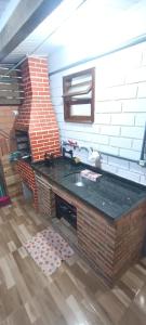 Una cocina con encimera y pared de ladrillo. en Apartamento com churrasqueira 400 metros da praia, en Florianópolis