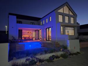 a house with a swimming pool at night at Yzer Heights Relaxed Luxury Stay in Yzerfontein