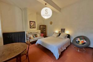 een slaapkamer met een bed en een tafel erin bij Studio Voltaire Arles Centre in Arles