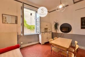 een woonkamer met een eettafel en een raam bij Studio Voltaire Arles Centre in Arles