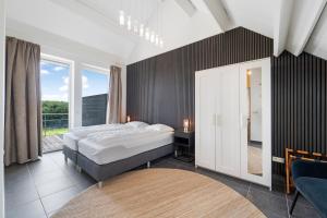 una camera da letto con un letto e una grande finestra di Wijndomein Joris a Slenaken