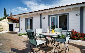 Villa la Paz by Villas Vista Gomera في أديخي: فناء مع طاولة وكراسي أمام المنزل