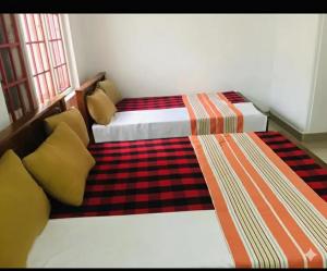 two twin beds in a room with two windows at NK Hotel and Restaurant in Matale