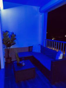 une chambre bleue avec un canapé et une table sur un balcon dans l'établissement Appartement moderne & cosy - proche des plages, à Fréjus 6 autres photos