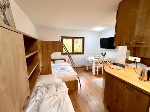 a room with two beds and a kitchen with a table at Sunflower in Kranjska Gora