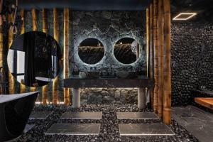 a bathroom with a stone wall with a sink and mirrors at KADOR HOME HOTEL downtown in Kyiv +121 photos