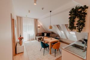Una cocina y una sala de estar con mesa y sillas. en Villa Garden Apartments, en Poprad