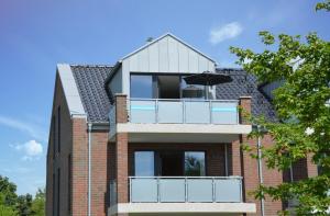 a building with a balcony with an umbrella at Kirschgarten 17 in Kellenhusen