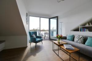 a living room with a couch and a table at Kirschgarten 17 in Kellenhusen +17 photos