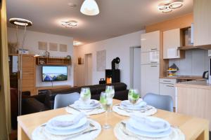 a kitchen and a dining room with a table with glasses at Seedüne 1 in Großenbrode