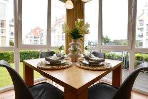 a dining room with a wooden table and chairs at Seedüne 1 in Großenbrode