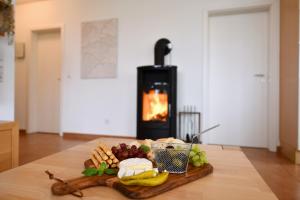 a tray of cheese and other foods on a table with a fireplace at Seedüne 1 in Großenbrode