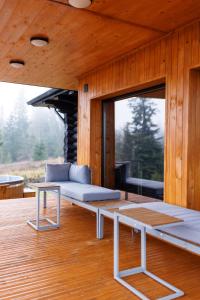 ein Zimmer mit einer Couch und einer Bank auf einer Terrasse in der Unterkunft Blackwood Retreat in Neagra Şarului + 37 Fotos