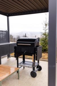 einen Grill auf einem Balkon mit Stadtblick in der Unterkunft Blackwood Retreat in Neagra Şarului