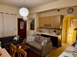 a living room with a couch and a kitchen at Sissy sweet Home in Elátia