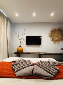 a bedroom with a bed with three towels on it at Jaguarype Bangalôs in Fortim