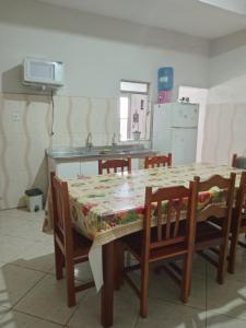 a kitchen with a table and chairs with a table and a kitchen at Casa Neia Castro com Piscina e garagem perto da Basilica in Aparecida
