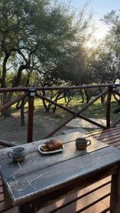 a wooden table with a plate of food on it at Zelenaiplava dormis in Merlo +11 photos