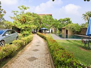 Un camino de ladrillos frente a una casa con un coche. en Blue Villa Wadduwa, en Wadduwa 23 fotos más