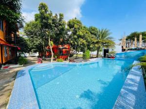 a large blue swimming pool with trees in the background at Green Zone Cottage 