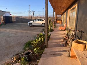 a white car parked in a parking lot next to a building at Chagual Los Vilos Lodging in Los Vilos