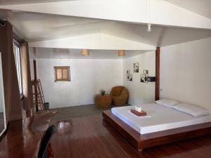 Tribal Xperience Guesthouse في سان فيسنتي: غرفة نوم بها سرير وطاولة في الغرفة