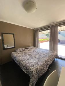 a bedroom with a bed and a mirror and a window at Back Packer Style in Durban