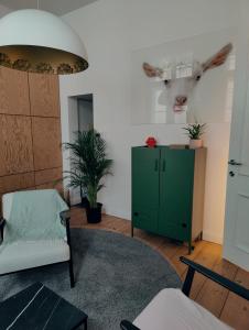 a living room with a green cabinet and a deer head on the wall at b&b les invités in Bruges +62 photos
